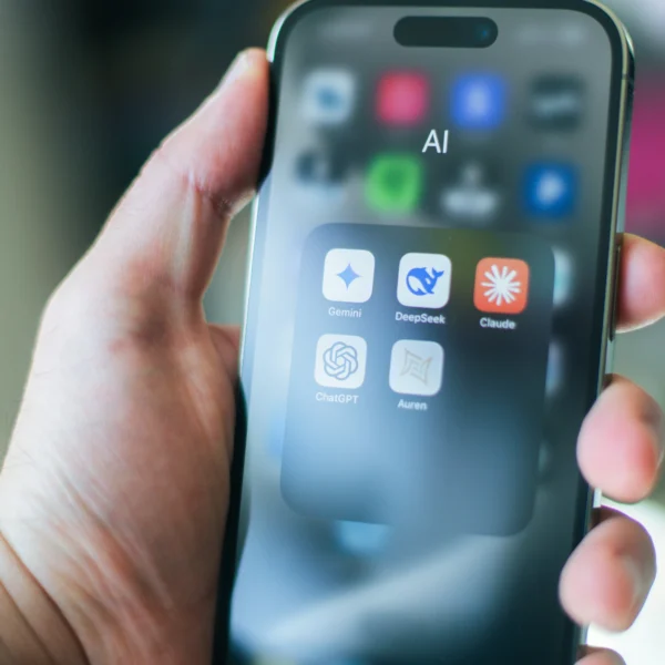 Iphone в руках людини на якому відкрита папка з інструментами ШІ(LLM): Клауд,Чат ГПТ, Діп Сік