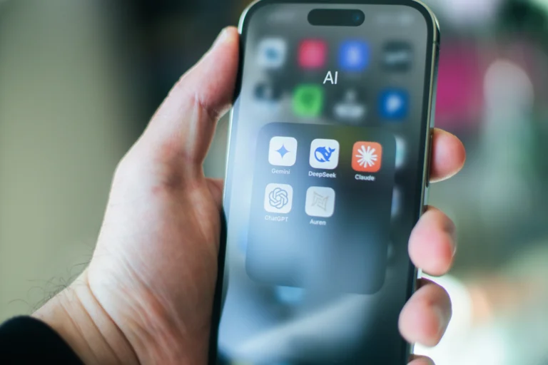 Iphone в руках людини на якому відкрита папка з інструментами ШІ(LLM): Клауд,Чат ГПТ, Діп Сік